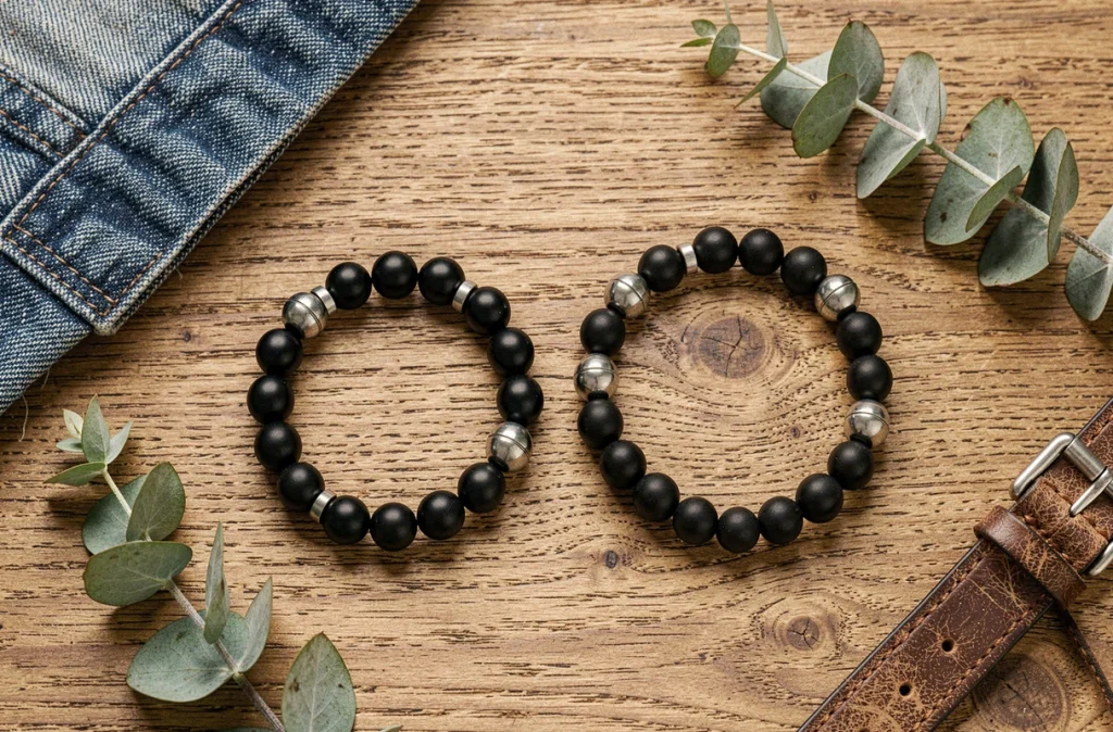Vue à plat de bracelets assortis homme femme en onyx noir et argent brossé sur une surface en bois brut