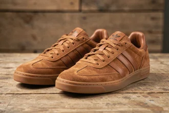 Paire de sneakers Adidas Spezial marron posée sur une surface en bois vieilli, vue de trois quarts