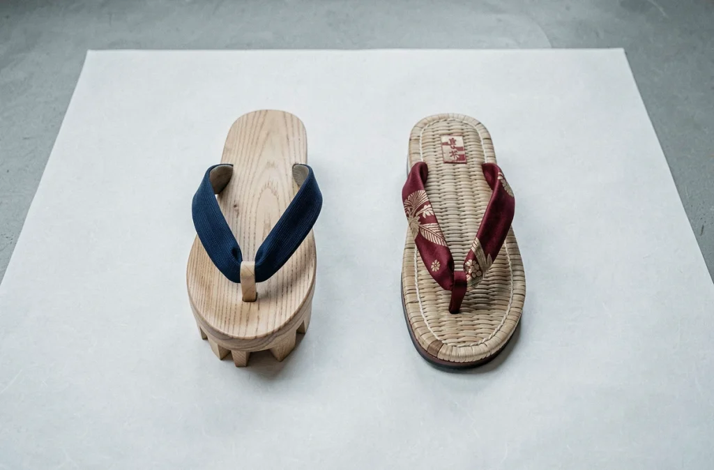 Comparaison côte à côte d'une sandale japonaise geta en bois surélevé et d'une sandale zori plate en paille laquée sur du papier washi blanc